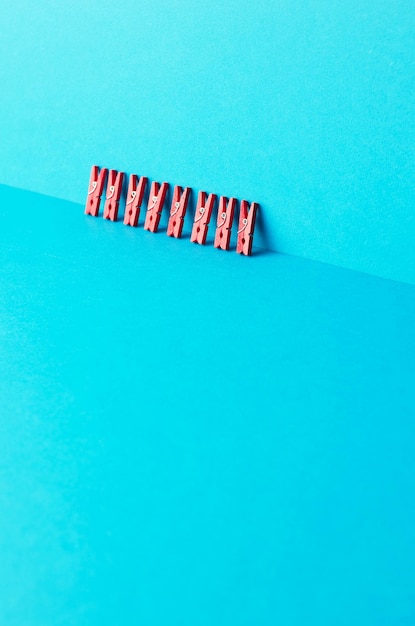 Pinces à linge rouges penchées sur fond bleu