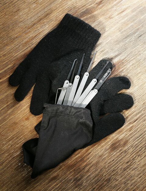 Photo des pinces à serrure avec des gants sur une table en bois