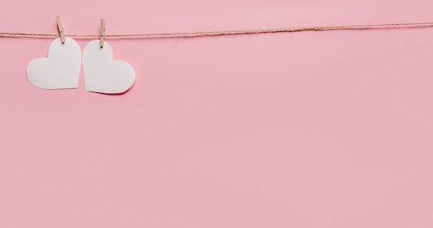 Épingle blanche de coeur sur une corde sur le concept rose d'isolement de fond, d'amour et de valentine