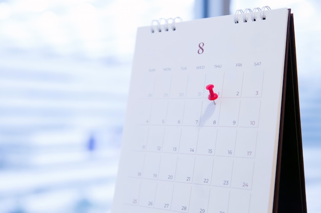 Épinglette rouge sur le calendrier pour la planification des activités et la réunion.