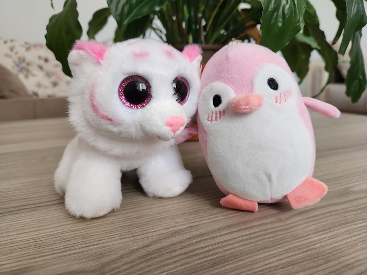 Photo un pingouin en peluche est assis à côté d'un animal en peluche.