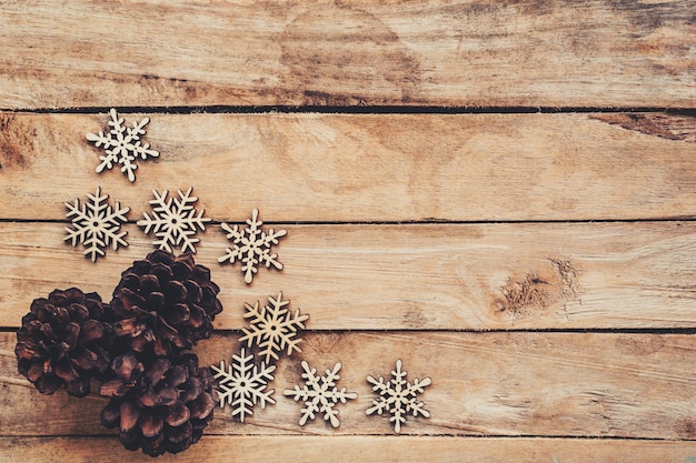 Pins de pin et flocons de neige sur bois pour un fond de noël avec de l&#39;espace.