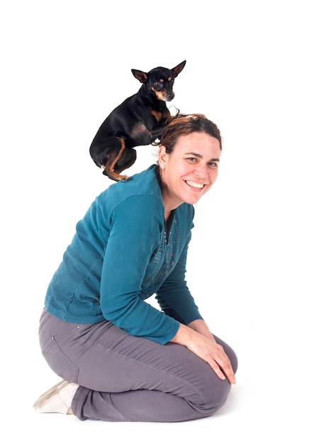 Pinscher en miniature et une femme dans le studio