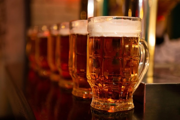 Pintes de bière sur un comptoir de bar dans un pub Concept de boisson alcoolisée de fête Chopes de bière en rangée sur un comptoir de bar Bière mousseuse concept de fête d'octobre