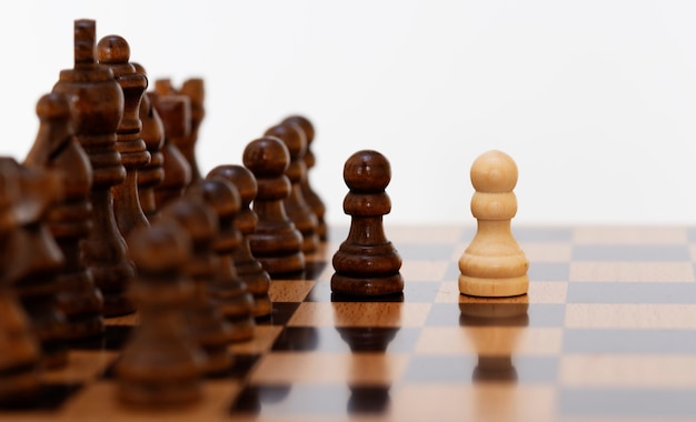 Pions d'échecs blancs sur l'échiquier en noir et blanc.