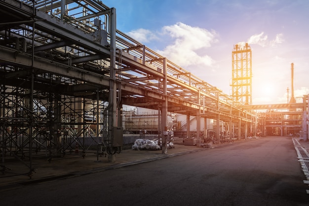 Pipeline et pipe rack de l'usine industrielle de pétrole avec fond de ciel coucher de soleil