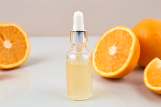 Pipeter avec de l'huile essentielle d'orange sur une bouteille et des oranges. Concept de médecine naturelle. Aromathérapie