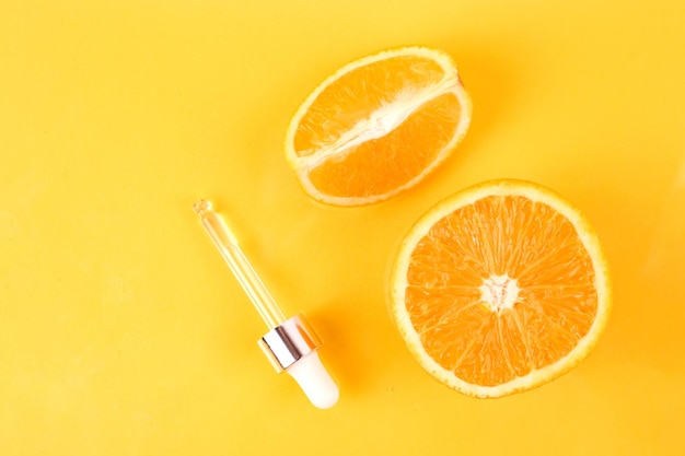 Photo pipeter avec de l'huile essentielle d'orange sur une bouteille et des oranges. concept de médecine naturelle. aromathérapie