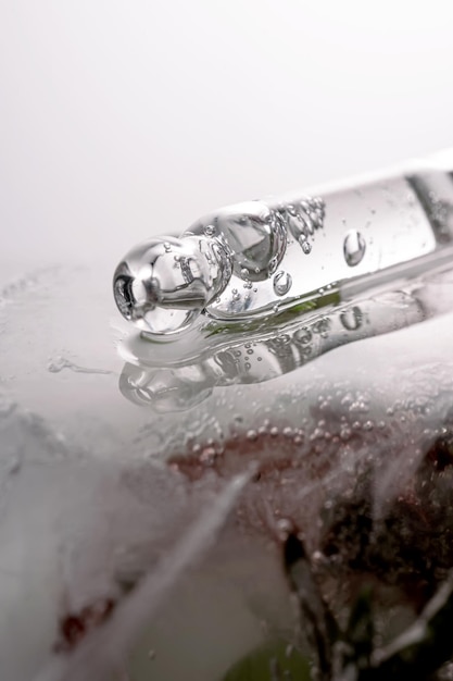 Pipette sur un grand morceau de glace avec des fleurs congelées