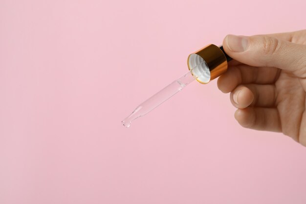 Pipette à main femelle avec de l'huile de pin sur rose