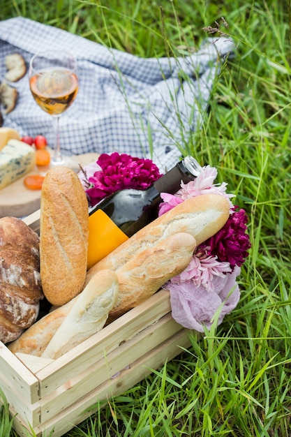 Pique-nique au parc sur l'herbe: vin, fromage et pain
