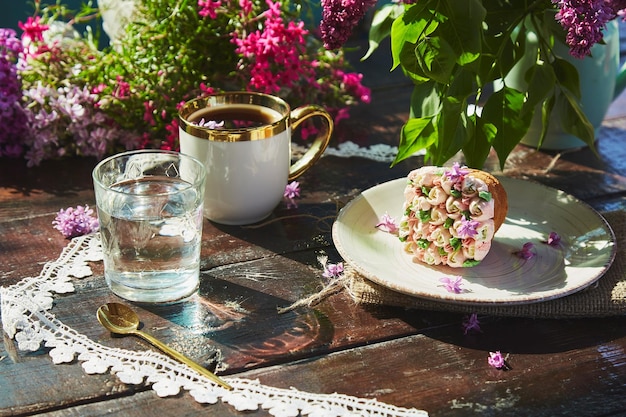 Pique-nique de jardin esthétique avec une tasse de café beau petit gâteau verre d'eau décoration de dentelle de fleurs