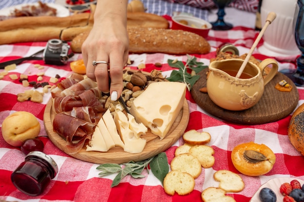 Pique-nique en plein air l'été. La nourriture, le miel et les fruits reposent sur une couverture à carreaux.