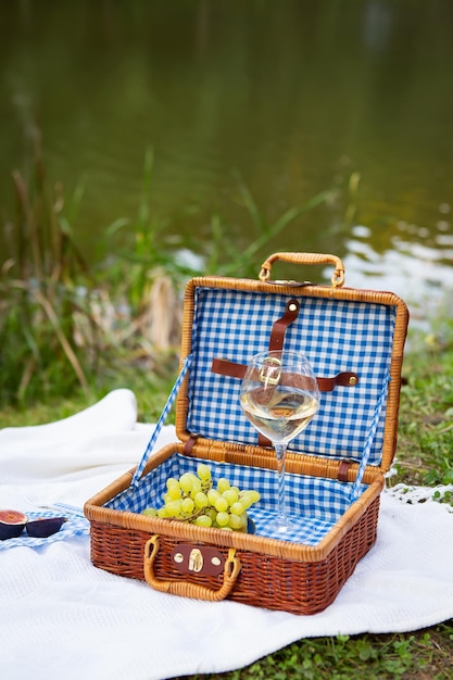 Pique-nique romantique dans le parc sur l'herbe sur fond d'un beau lac nourriture délicieuse