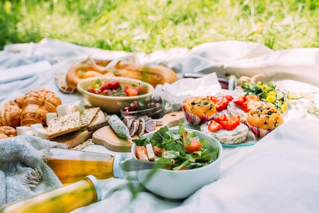 Pique-nique sur le terrain avec saucisse au fromage au jus de baies et croissants sucrés