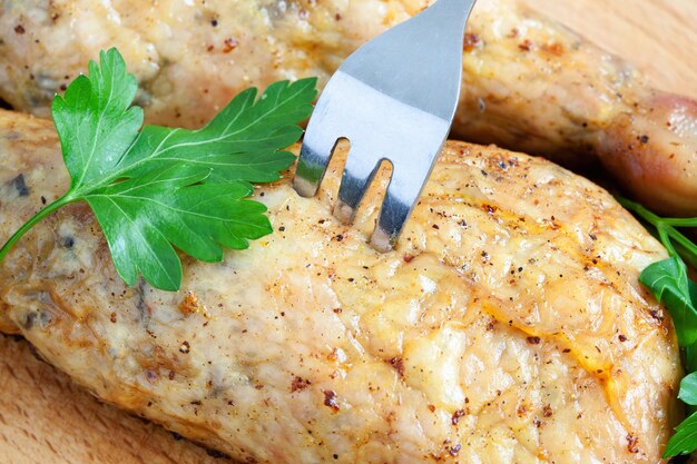 Piquer le poulet avec une fourchette sur une planche à découper