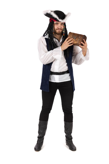 Un pirate en costume se tient debout et tient un petit coffre au trésor.