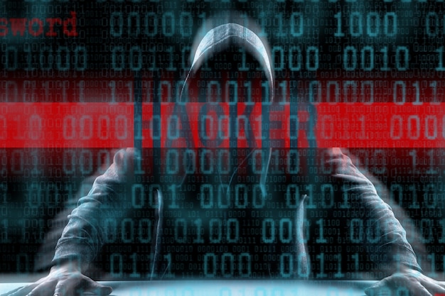 Un pirate imprime un code sur le clavier d'un ordinateur portable pour s'introduire dans un cyberespace