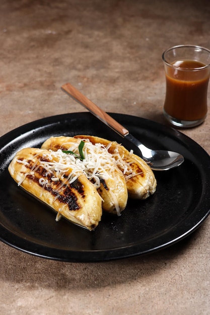 Pisang Gapit ou pisang Epe est une banane grillée avec une sauce à la cassonade à la noix de coco et une garniture au fromage