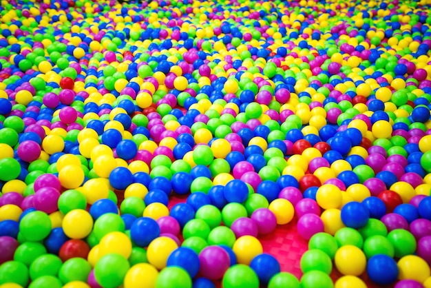Piscine avec des balles en plastique de vert, bleu, rose, rouge et jaune.