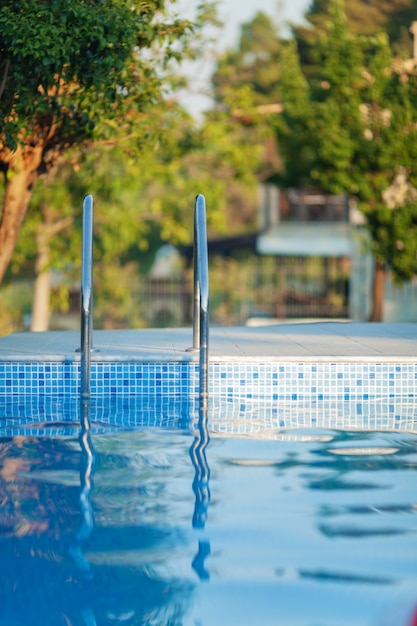 Photo piscine avec une balustrade brillante et une journée ensoleillée