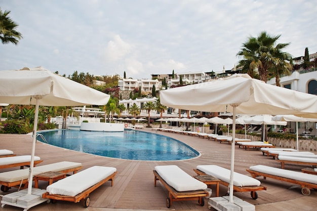 Piscine avec chaises longues le matin à l'hôtel de villégiature d'été méditerranéen en Turquie Bodrum