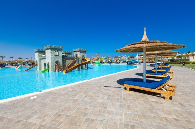 Piscine avec cocotier et parasol blanc