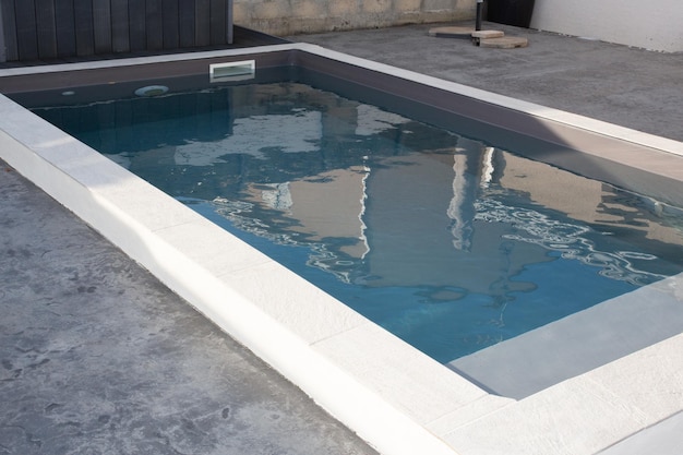 Piscine contemporaine en ciment avec escalier et bordure moderne à l'eau bleue