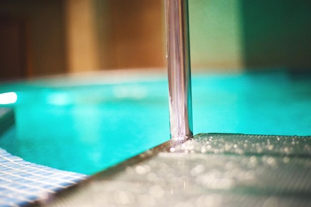 Piscine dans le centre de spa gouttes d'eau sur les escaliers menant à la piscine