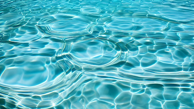 Une piscine avec de l'eau claire et le soleil se reflétant sur l'eau.