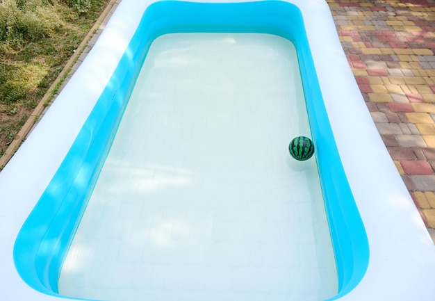 Piscine d'eau gonflable avec ballon flottant dans la cour arrière d'une résidence privée