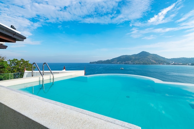 Piscine avec escalier au sommet du toit-terrasse donnant sur la mer tropicale, Villa de luxe sur la plage avec piscine vue mer au design moderne, vacances d'été et concept de fond de voyage.