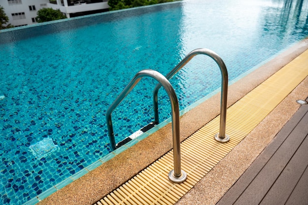 Piscine avec escalier et terrasse en bois à l'hôtel ou en copropriété