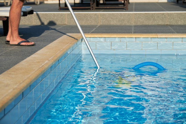 Piscine extérieure de nettoyage masculin avec tube à vide sous-marin.