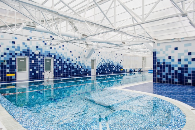 Piscine intérieure lumineuse moderne décorée de carreaux bleus