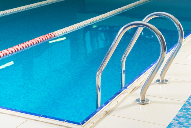 Piscine intérieure vide avec garde-corps et marches dans l'eau