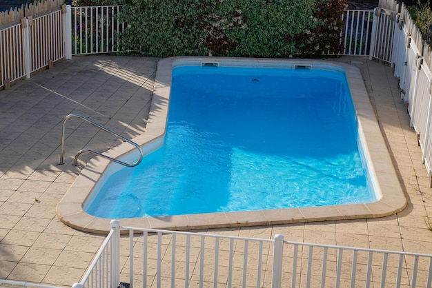 Piscine de jardin à la maison avec de l'eau bleue