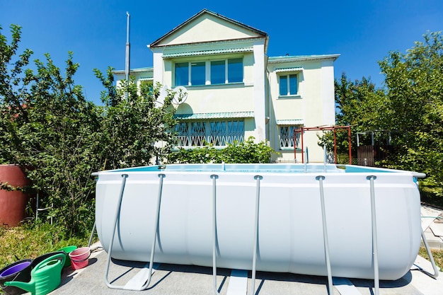 piscine à ossature dans le jardin d'une maison privée, été