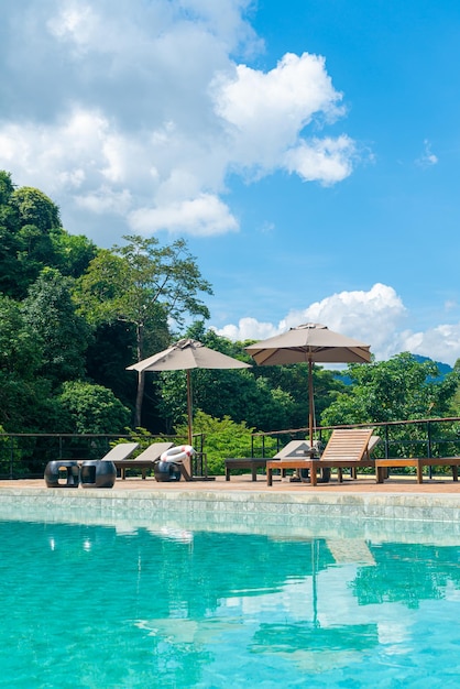 piscine avec parasol autour de la piscine avec fond de montagne et de ciel bleu