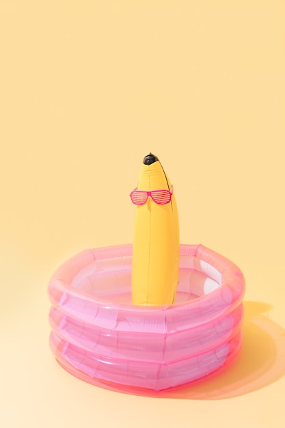 Piscine pour enfants avec une banane gonflable en forme de banane avec des lunettes de soleil