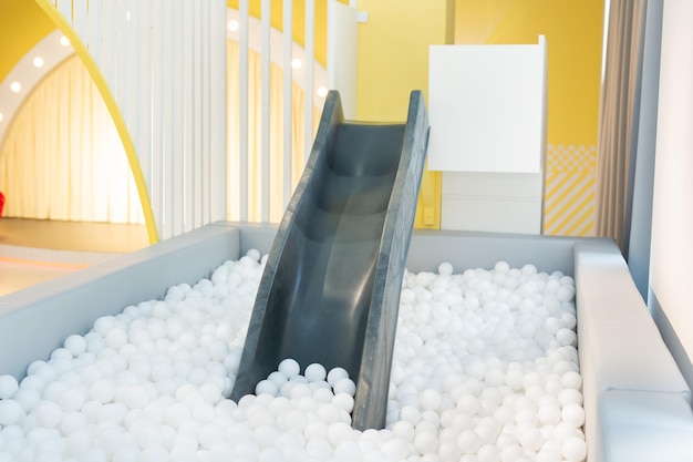 Une piscine sèche en plastique avec des balles et un toboggan pour les jeux et le sport