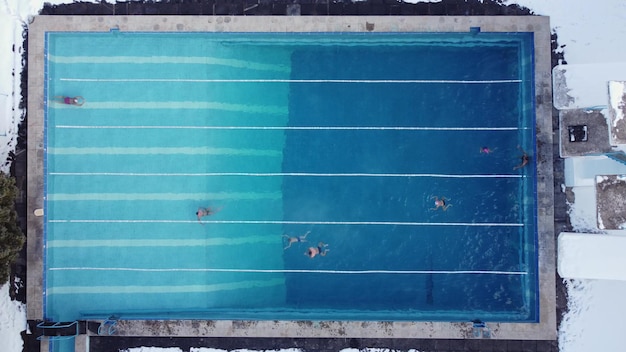 Piscine sportive extérieure ouverte toute l'année Les athlètes nagent dans la piscine en hiver Vue aérienne