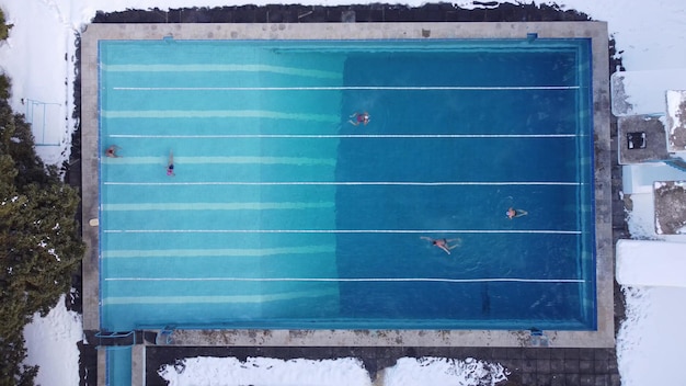 Piscine sportive extérieure ouverte toute l'année Les athlètes nagent dans la piscine en hiver Vue aérienne