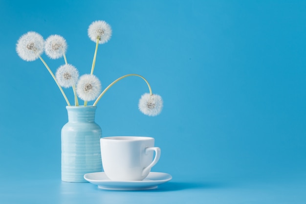 Pissenlits et tasse de thé sur bleu