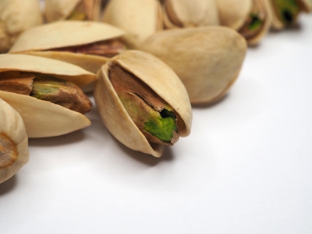 Pistaches éparpillées sur un gros plan de noix de table blanche