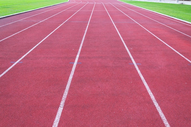Piste de course et herbe vertePiste de course d'athlétisme direct au stade sportif