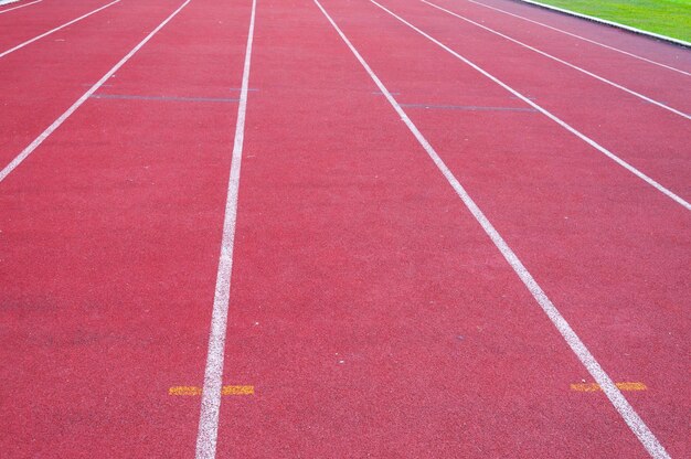 Piste de course et herbe vertePiste de course d'athlétisme direct au stade sportif