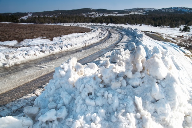 Photo piste sur route d'hiver avec de la neige profonde.