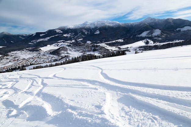 Piste de ski avec pistes de ski belle journée d'hiver vue du sommet de la montagne à la vallée