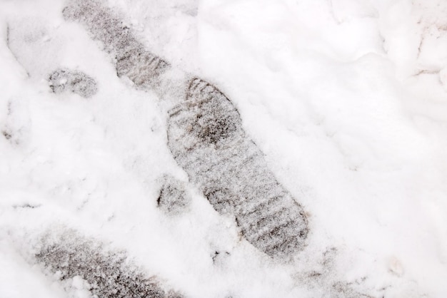 Pistes de chaussures sur la neige blanche se bouchent